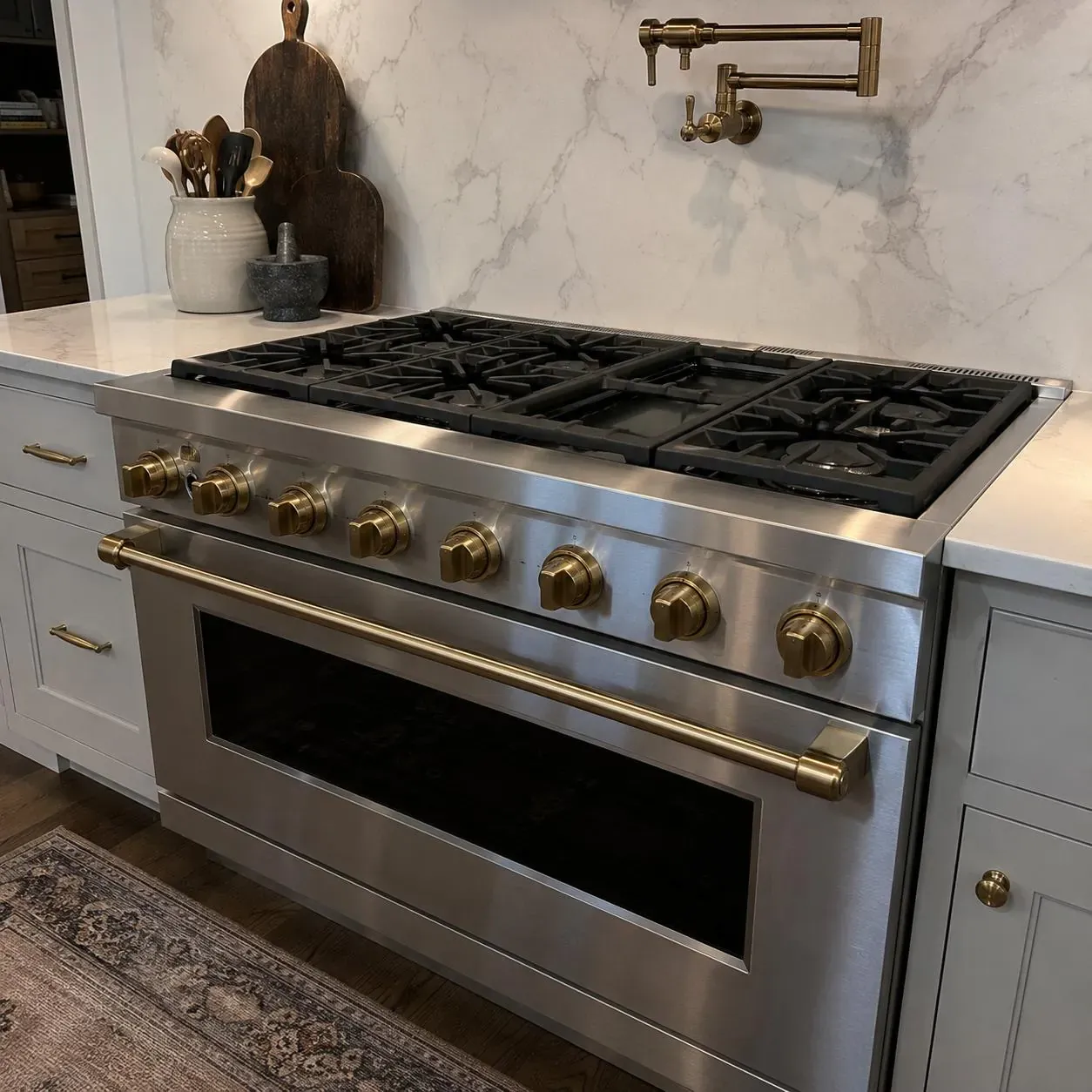 Professional stainless range with brushed-brass knobs and handle