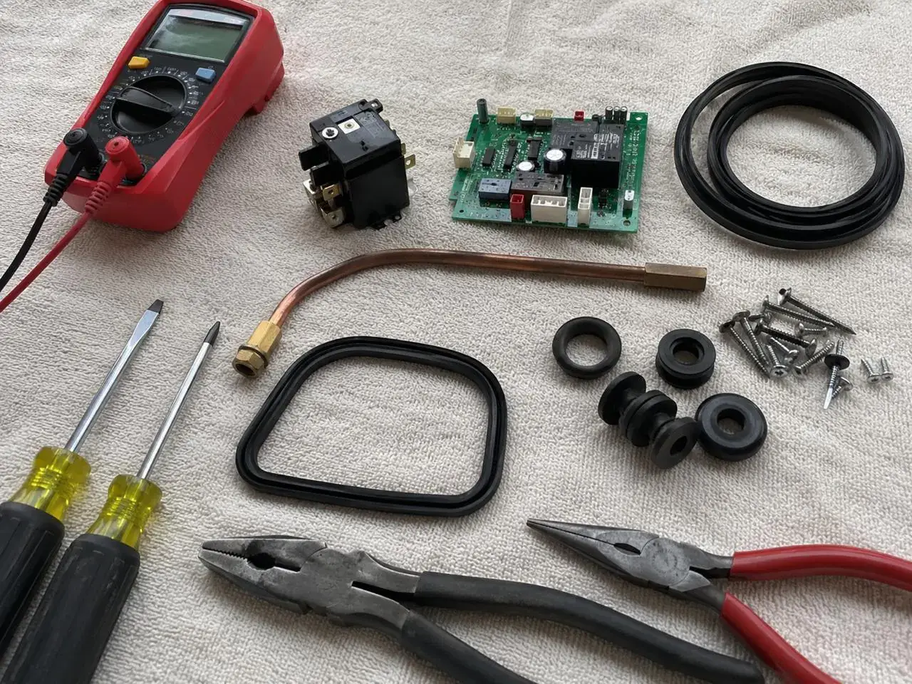 Genuine OEM appliance parts and professional tools laid out on a workbench