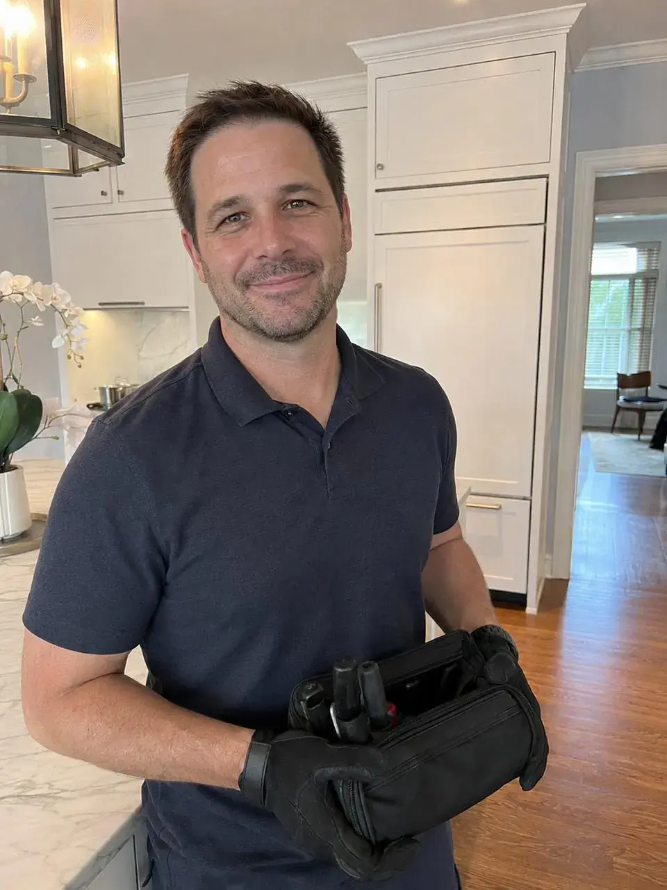 Factory-trained appliance repair technician with his tool bag in a luxury kitchen